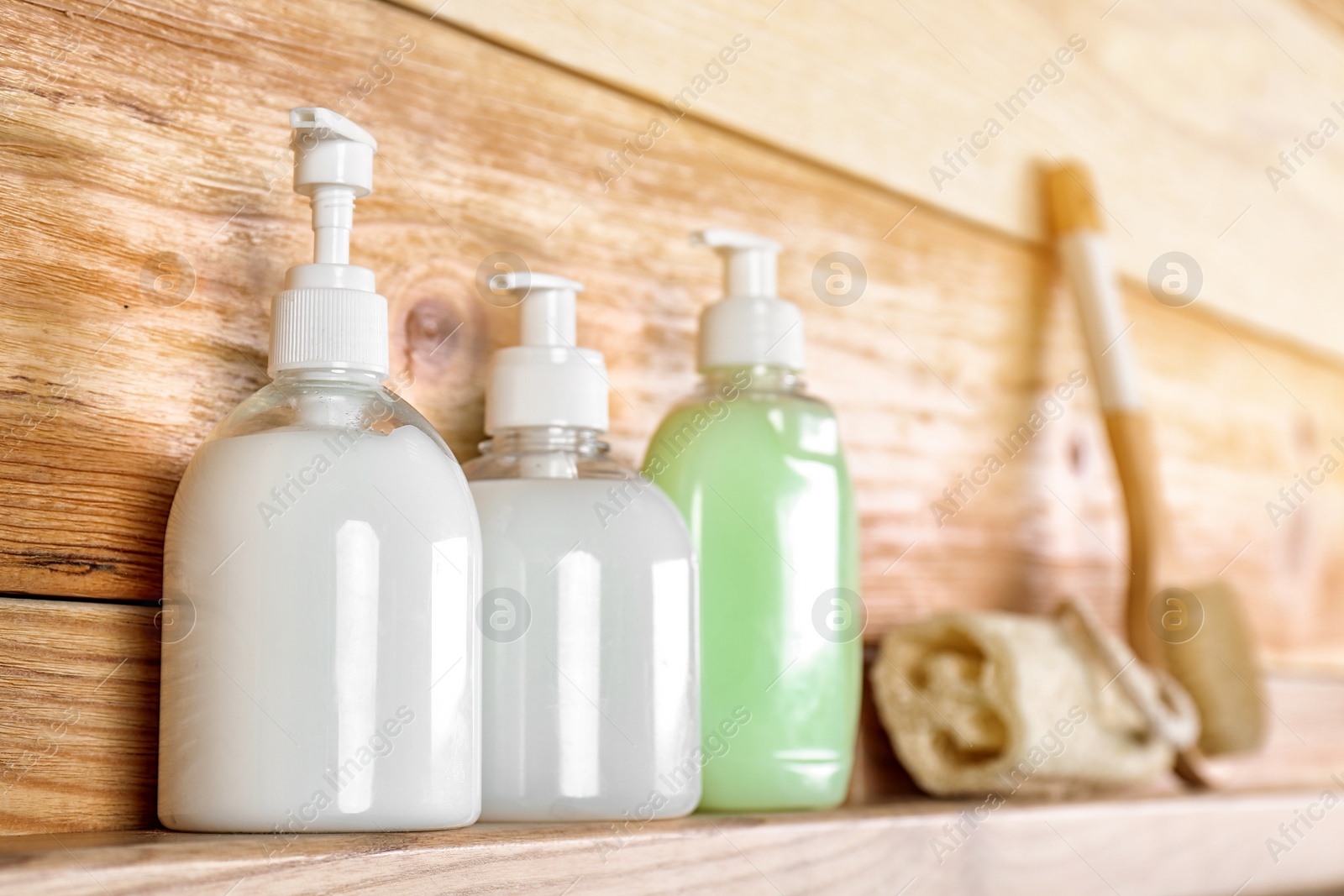 Photo of Soap dispensers on wooden shelf. Space for text