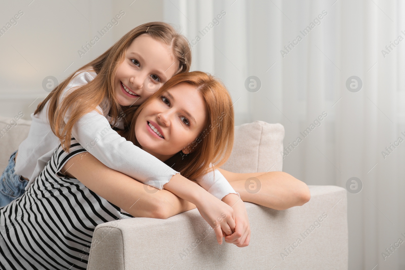 Photo of Mother and her cute daughter spending time together at home. Space for text