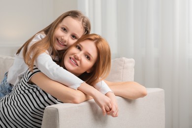 Photo of Mother and her cute daughter spending time together at home. Space for text