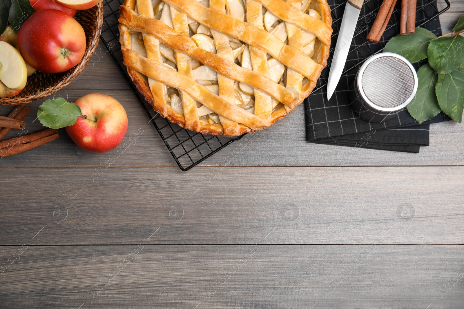 Photo of Delicious traditional apple pie on wooden table, flat lay. Space for text