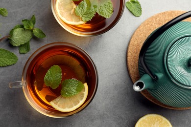Photo of Aromatic herbal tea with mint and lemon on grey table, flat lay