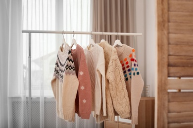 Wardrobe rack with stylish warm clothes indoors