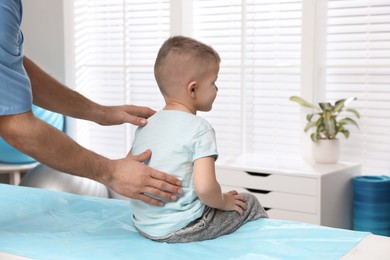 Orthopedist examining child's back in clinic, closeup. Scoliosis treatment