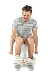 Photo of Young man suffering from diarrhea on toilet bowl. Isolated on white