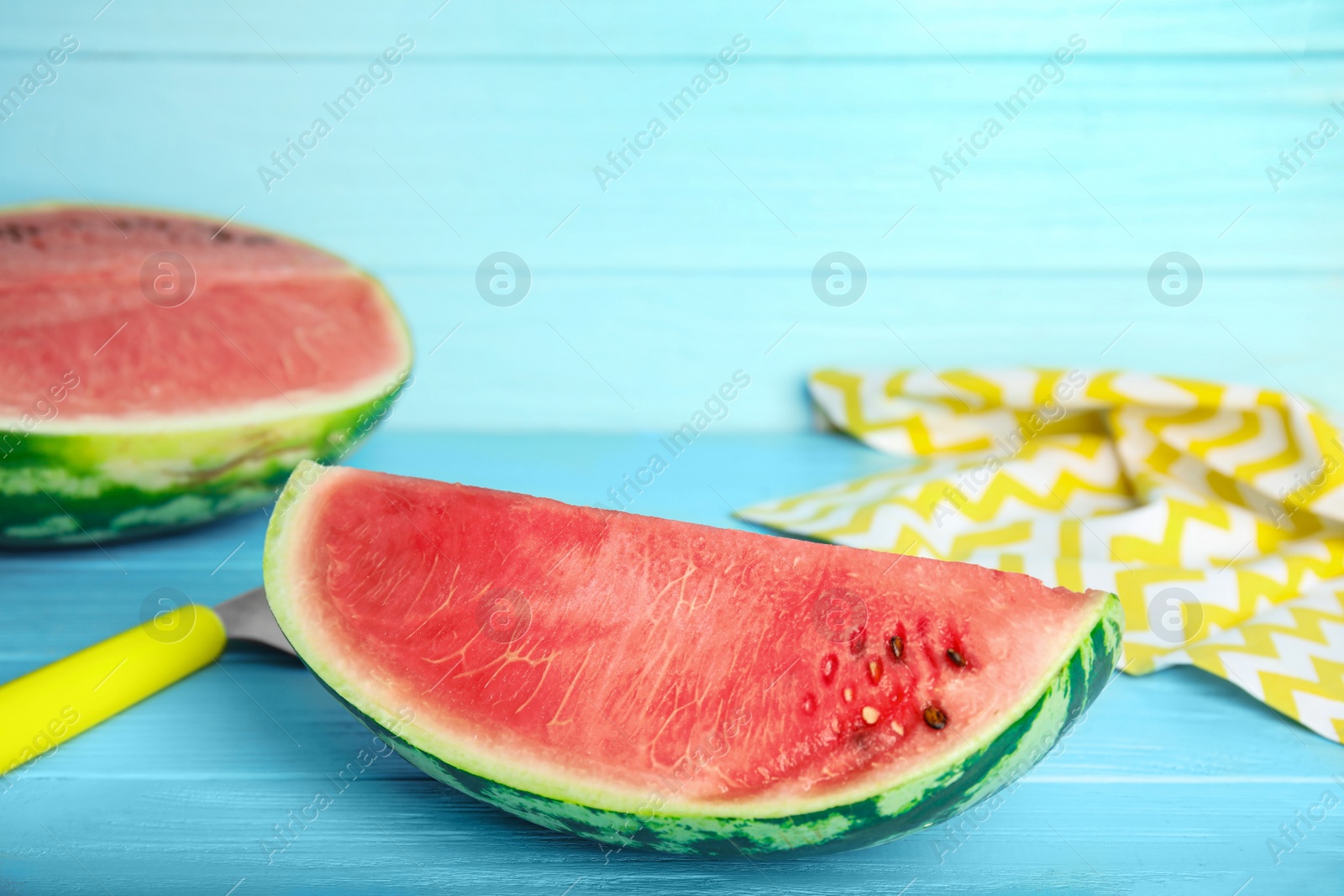 Photo of Yummy cut watermelon on light blue wooden table