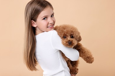 Little child with cute puppy on beige background. Lovely pet