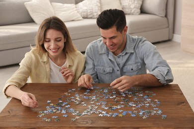 Happy couple playing with puzzles at home