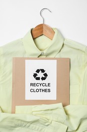 Photo of Shirt and card with recycling symbol on white background, closeup