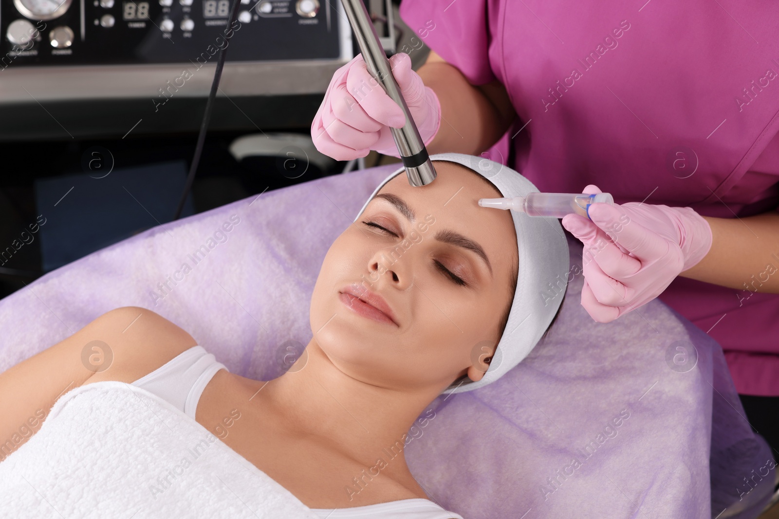 Photo of Young woman undergoing cosmetic procedure in beauty salon. Microcurrent therapy