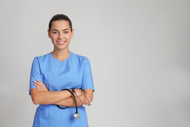 Photo of Portrait of young medical assistant with stethoscope on color background. Space for text