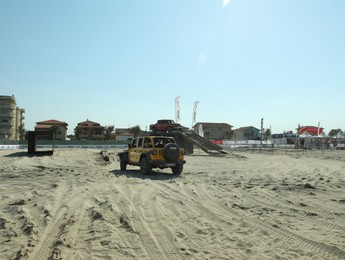 Photo of SENIGALLIA, ITALY - JULY 22, 2022: Jeep test drive on sand outdoors. Car presentation