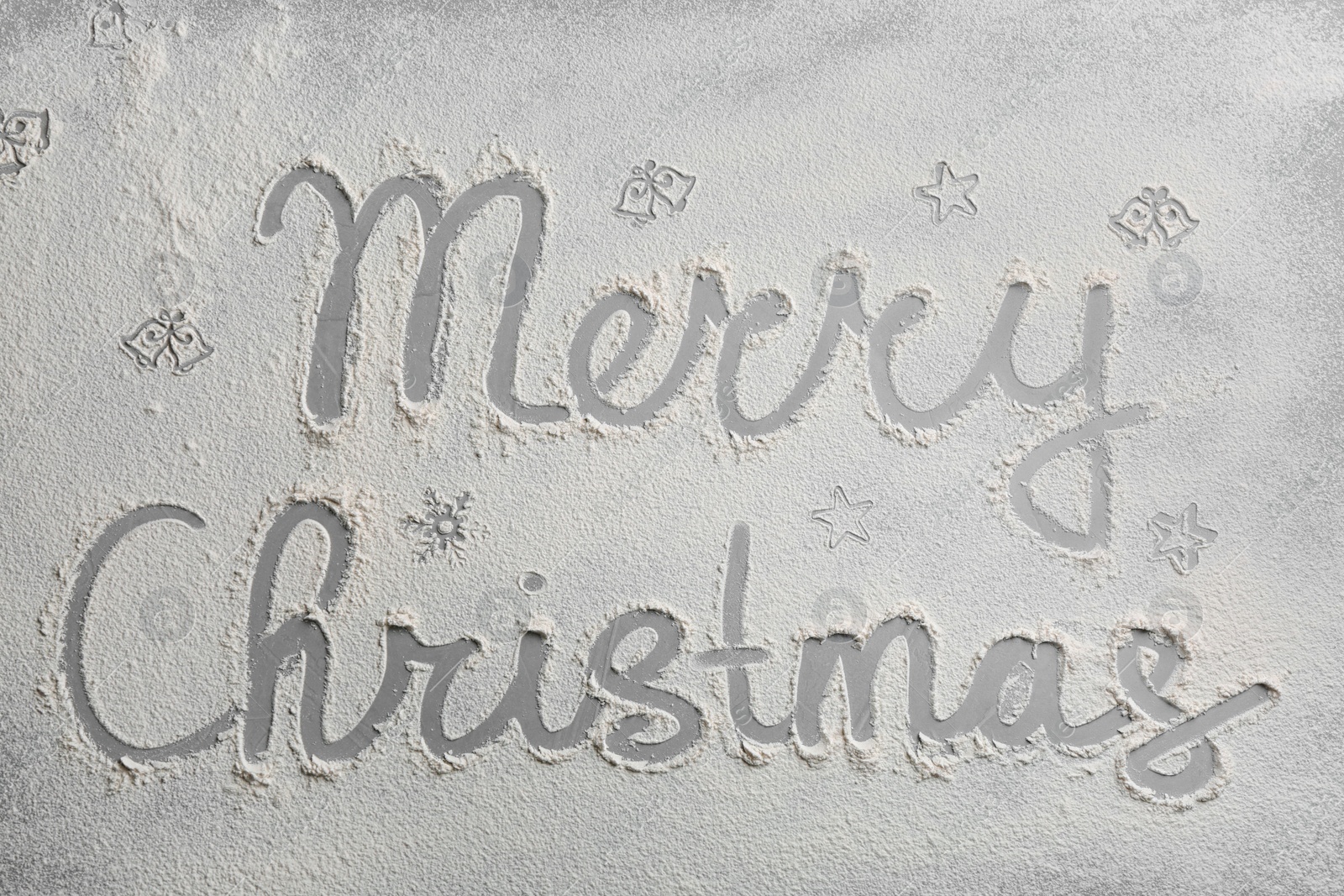 Photo of Different drawings and phrase Merry Christmas made of flour on grey table, top view