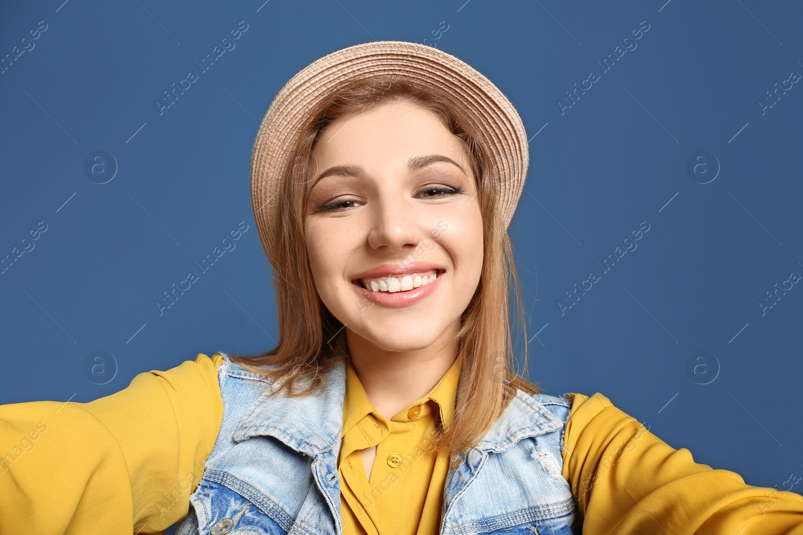 Photo of Attractive young woman taking selfie on color background