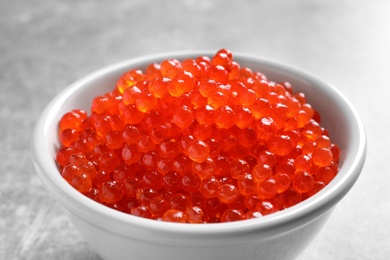 Ceramic bowl with delicious red caviar on table, closeup