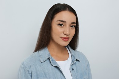 Photo of Portrait of beautiful young woman in jeans jacket on white background