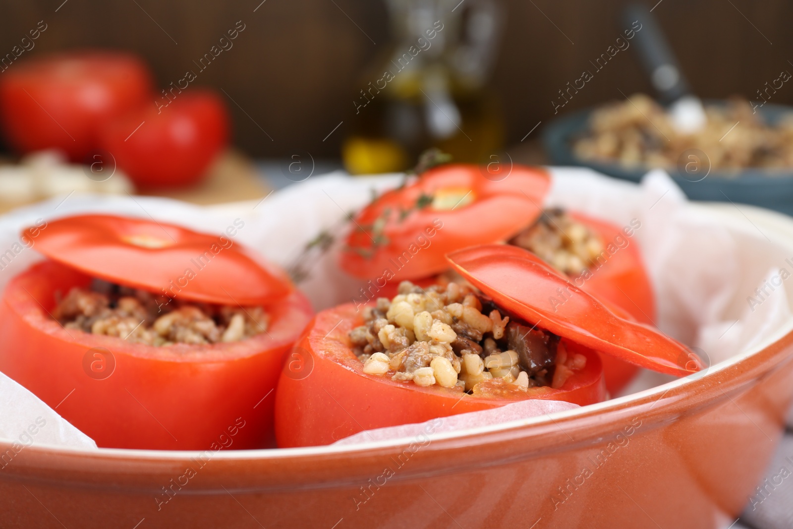 Photo of Uncooked stuffed tomatoes with minced beef, bulgur and mushrooms in baking dish, closeup