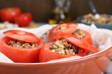 Uncooked stuffed tomatoes with minced beef, bulgur and mushrooms in baking dish, closeup