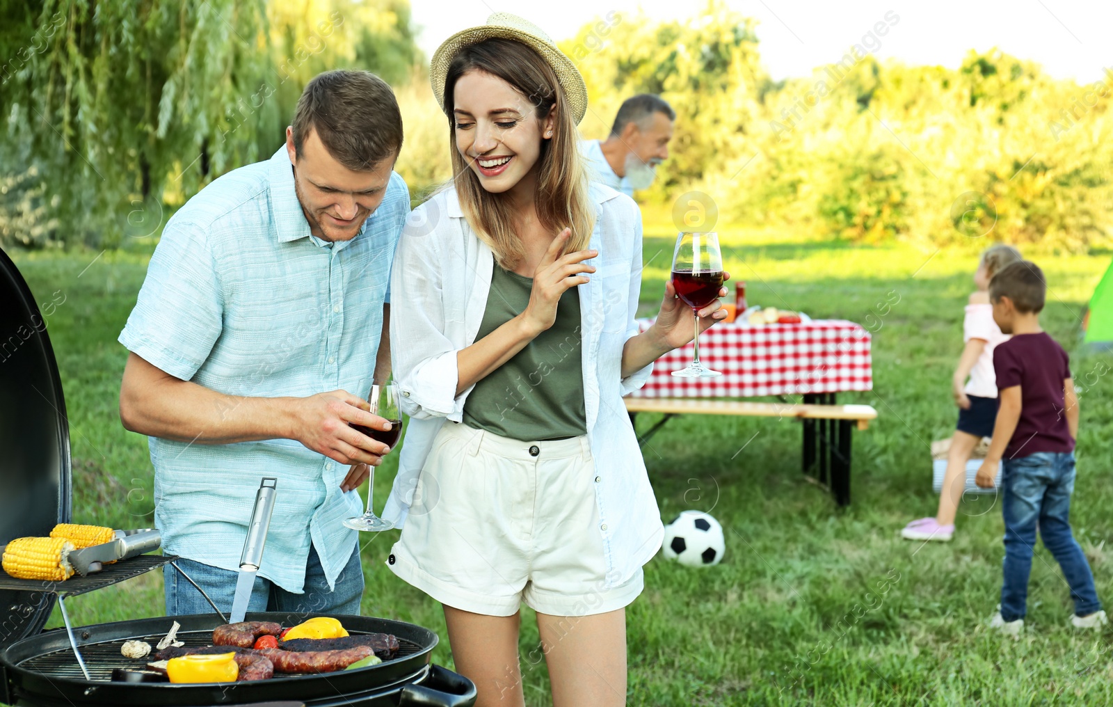 Photo of Happy family having barbecue in park on sunny day