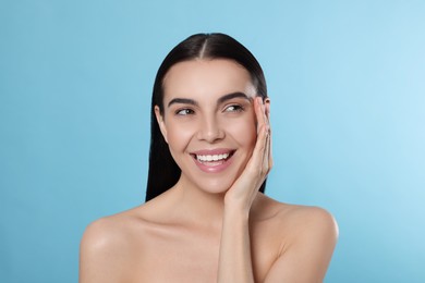 Portrait of attractive young woman on light blue background. Spa treatment