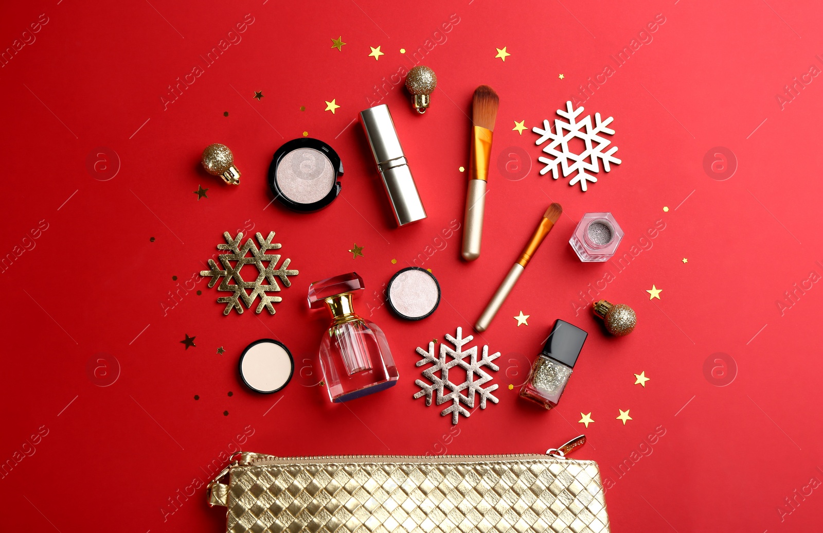 Photo of Flat lay composition with decorative cosmetic products on red background. Winter care