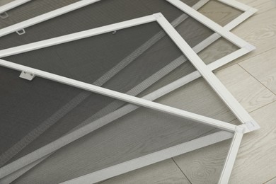 Set of window screens on wooden floor, closeup