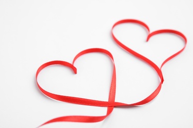 Photo of Hearts made of red ribbon on white background. Valentine's day celebration