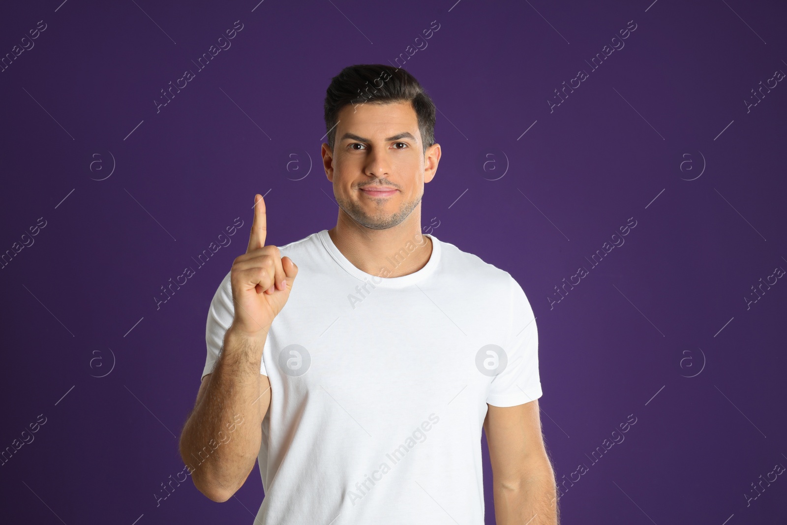 Photo of Man showing number one with his hand on purple background