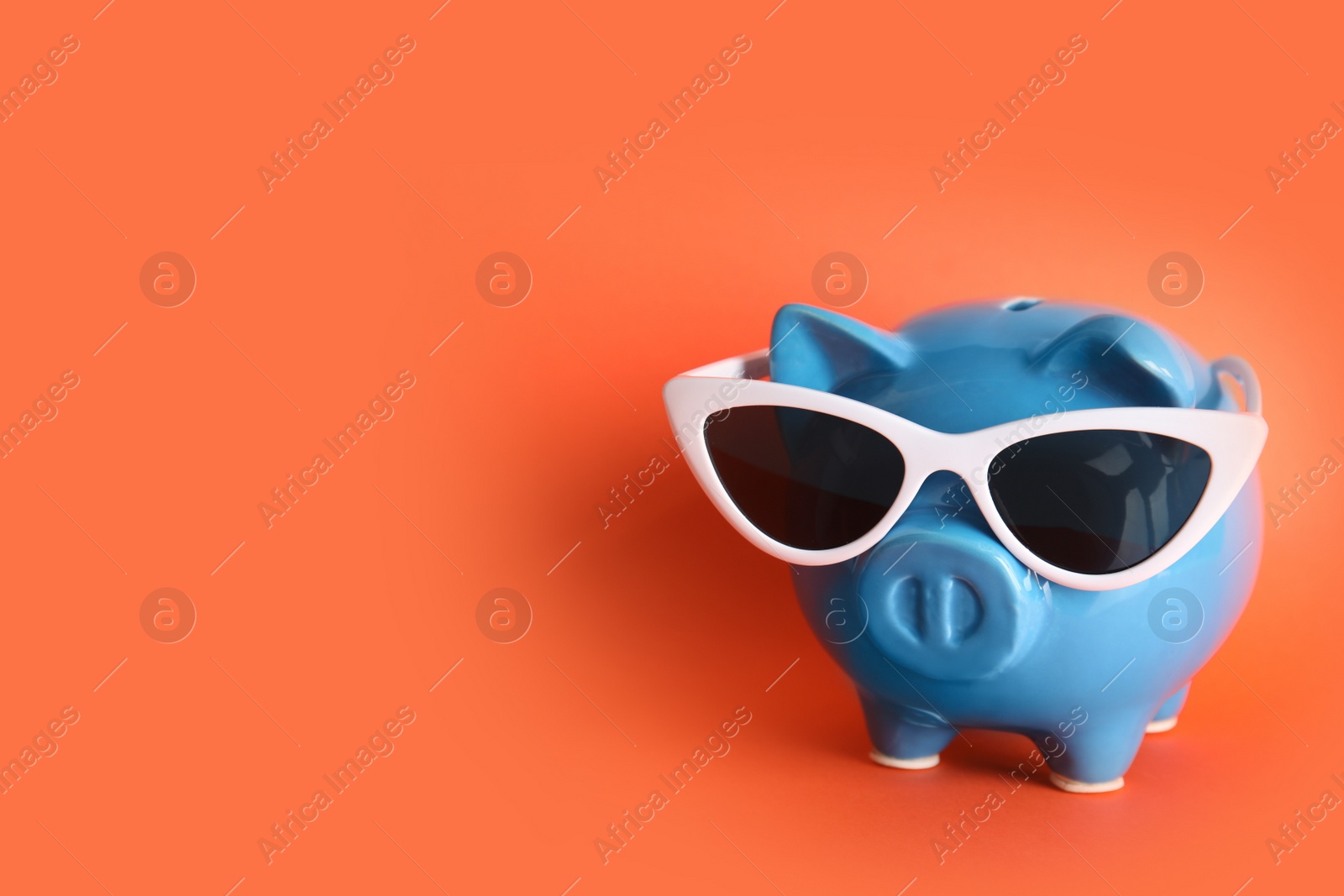 Photo of Piggy bank with sunglasses on color background, space for text. Travel agency