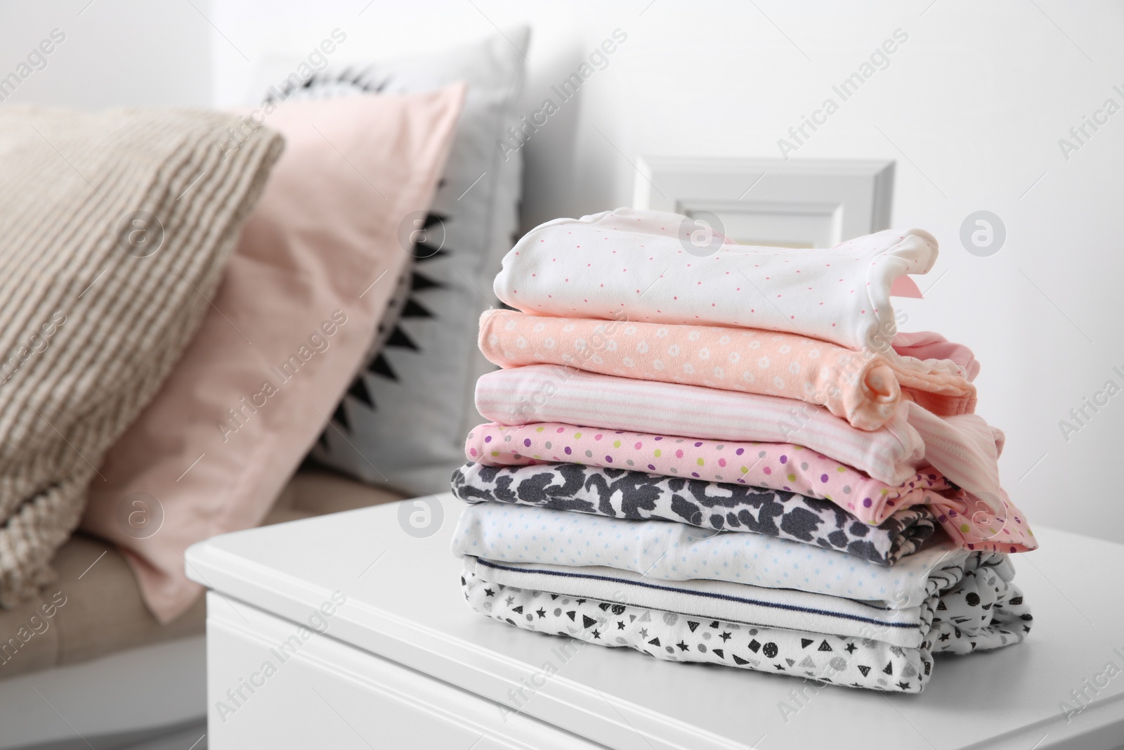 Photo of Stack of stylish child clothes on table indoors