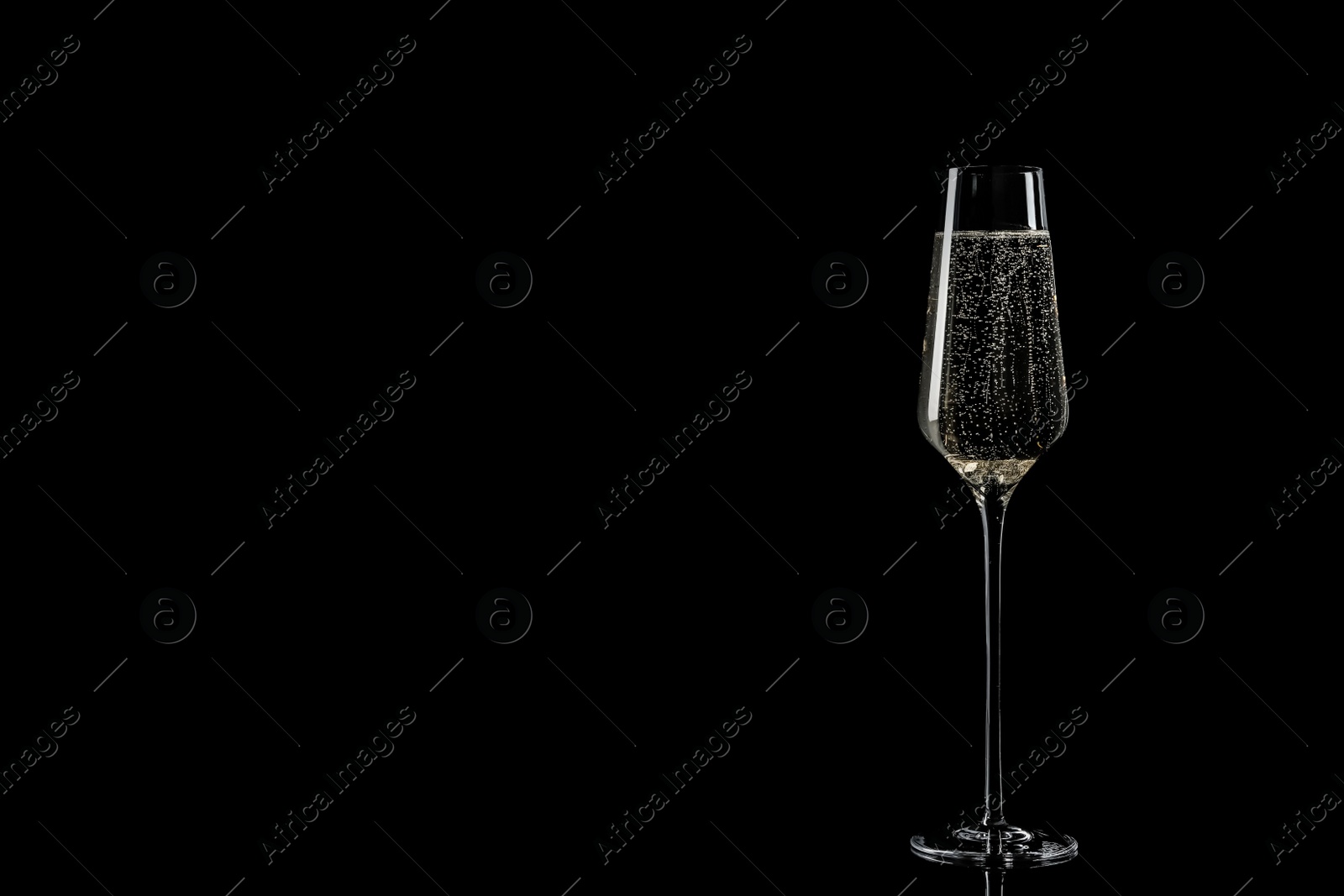 Photo of Glass of champagne on black background, space for text