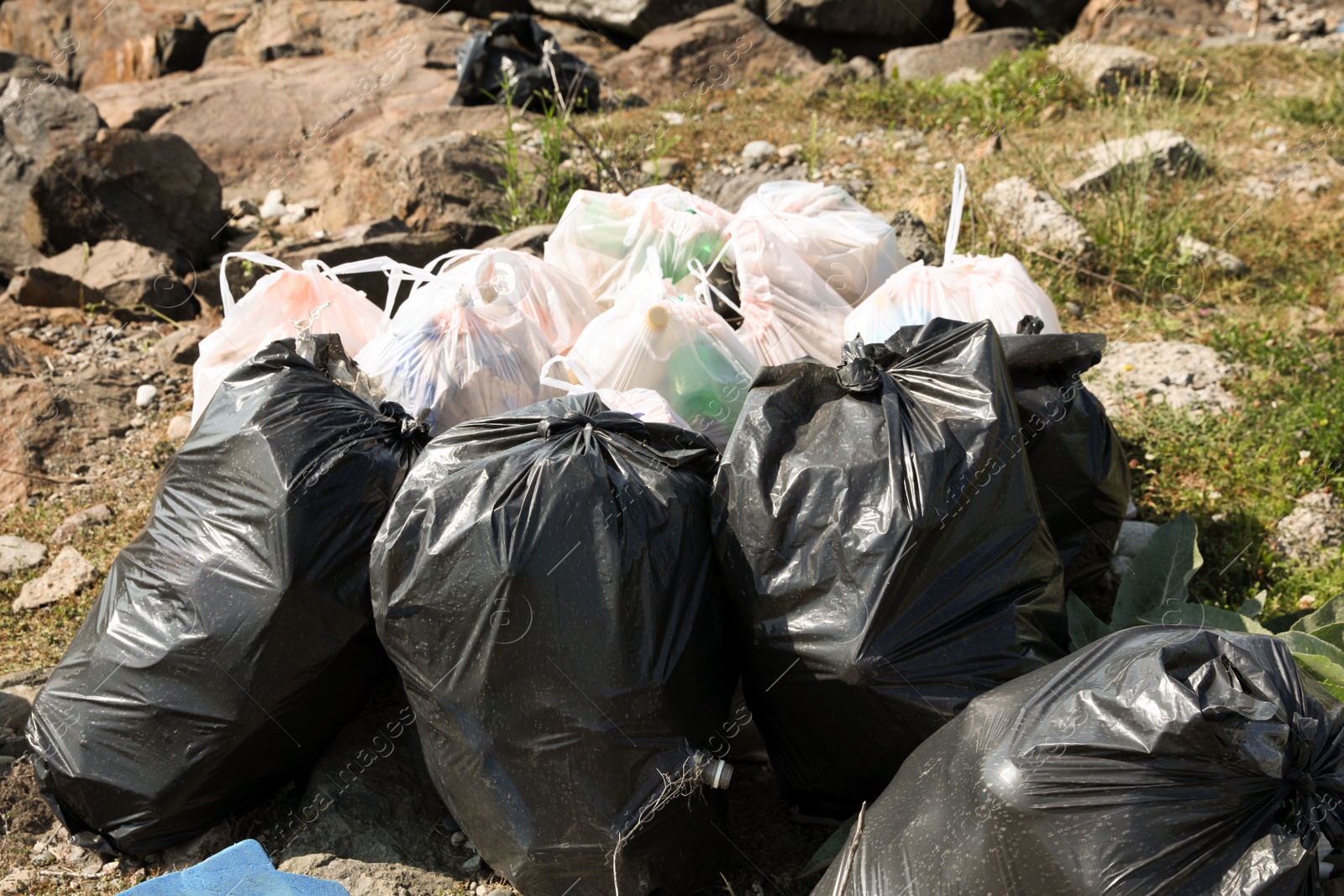 Photo of Many trash bags full of garbage outdoors. Environmental Pollution concept