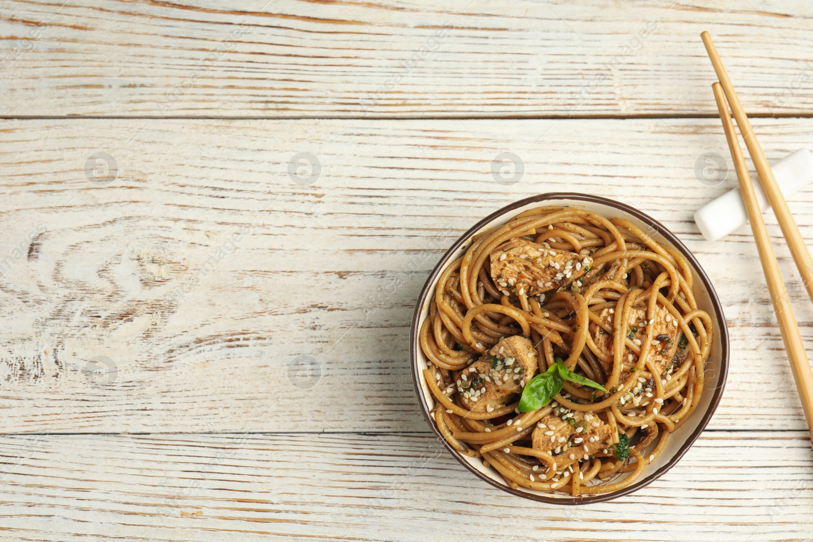 Photo of Tasty buckwheat noodles with meat on white wooden table, flat lay. Space for text