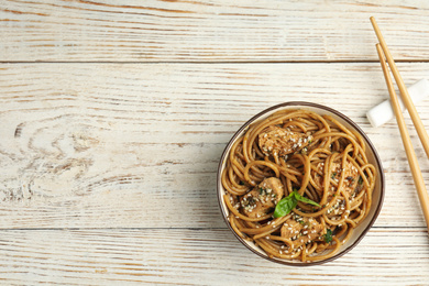 Photo of Tasty buckwheat noodles with meat on white wooden table, flat lay. Space for text