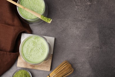 Tasty matcha smoothie, bamboo spoon and whisk on brown table, flat lay. Space for text