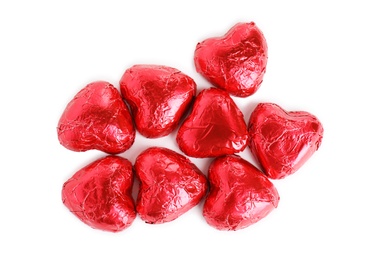 Photo of Heart shaped chocolate candies on white background, top view