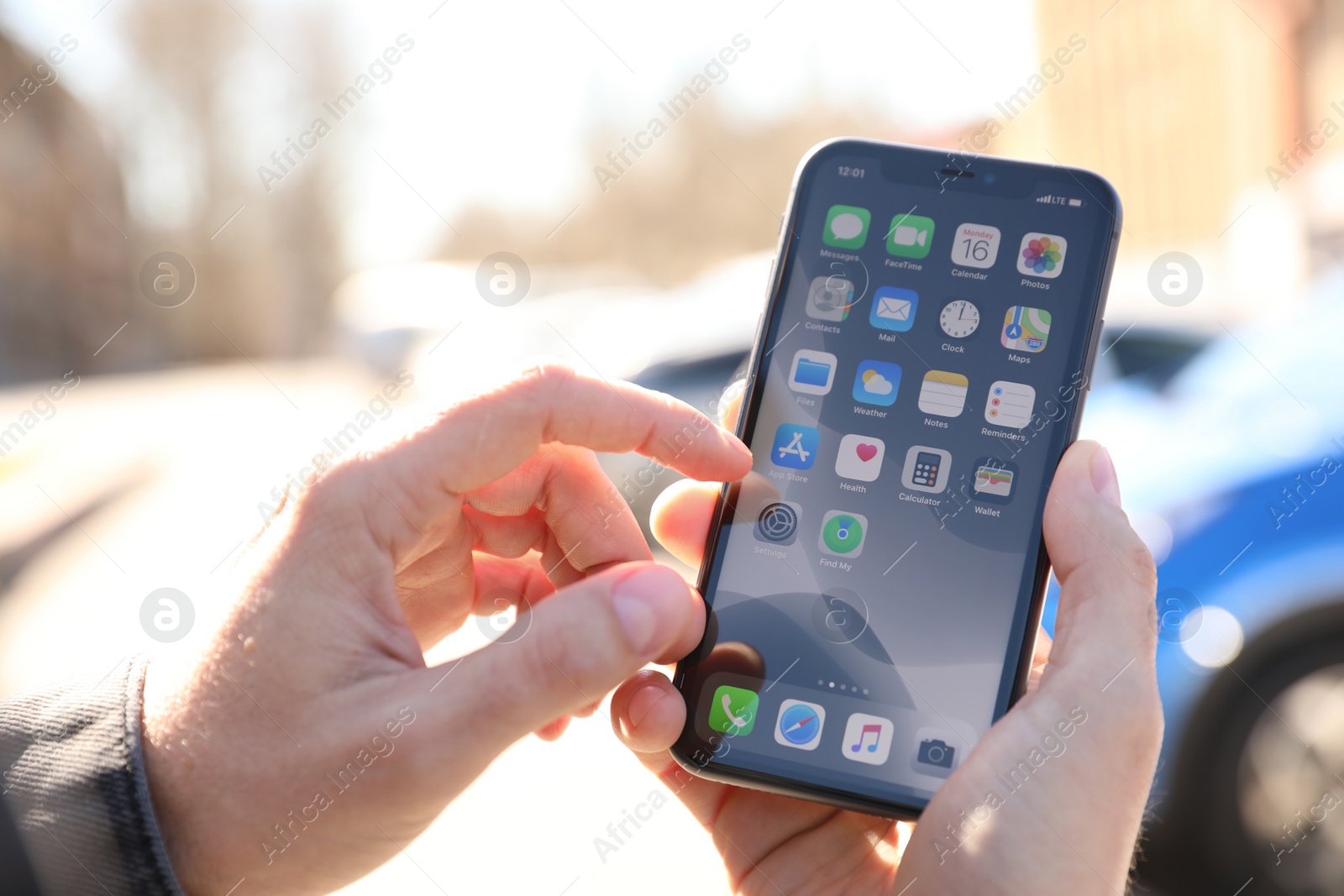 Photo of MYKOLAIV, UKRAINE - MARCH 16, 2020: Man holding iPhone 11 with home screen outdoors, closeup