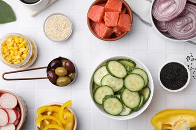 Photo of Ingredients for poke bowl on white checkered table, flat lay