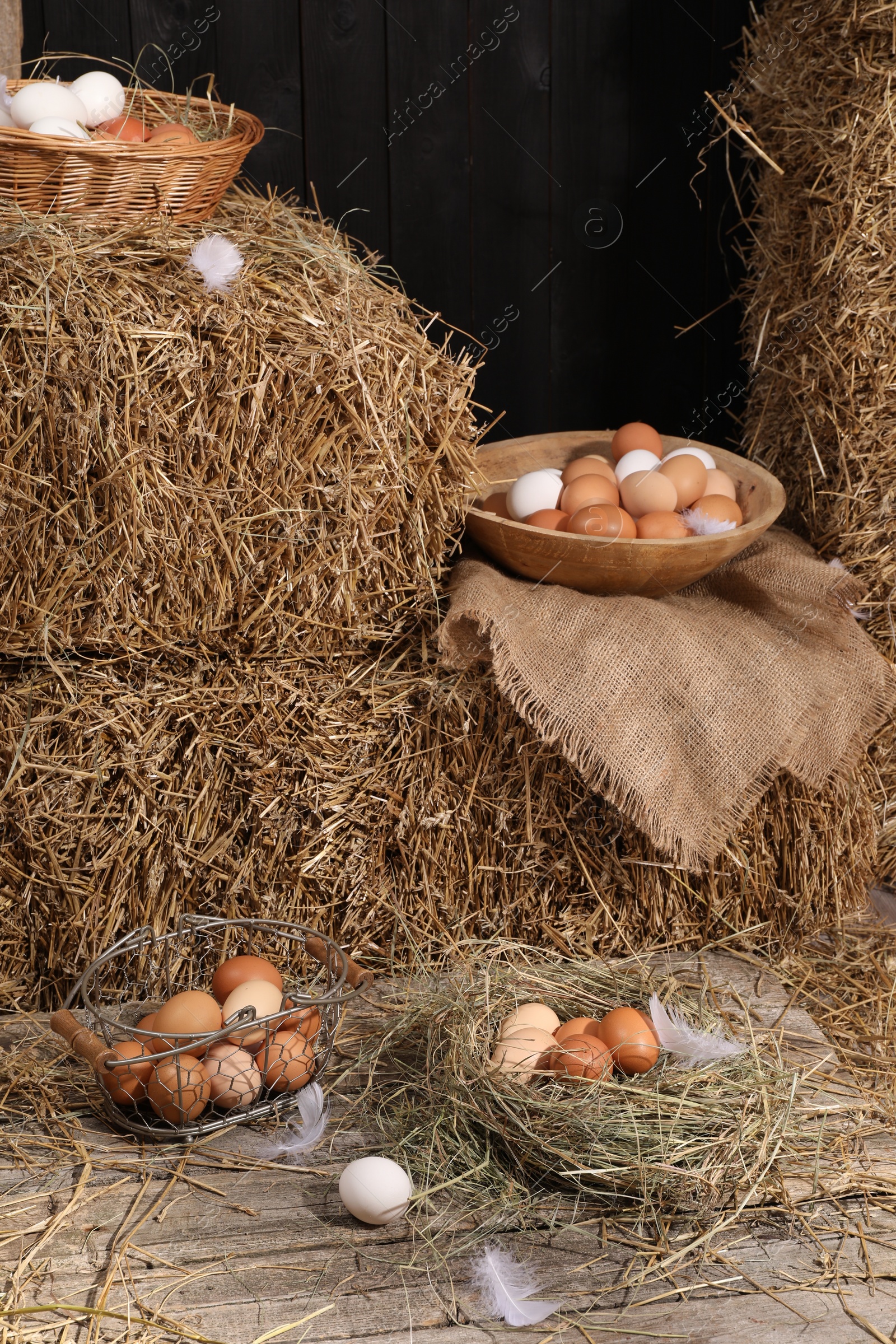 Photo of Fresh chicken eggs and dried straw bales in henhouse