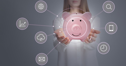 Different icons and young woman holding piggy bank on background, closeup 