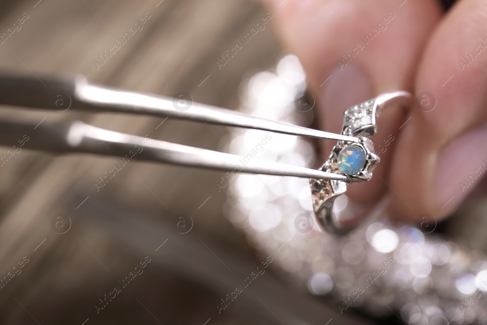 Photo of Male jeweler examining ring in workshop, closeup view