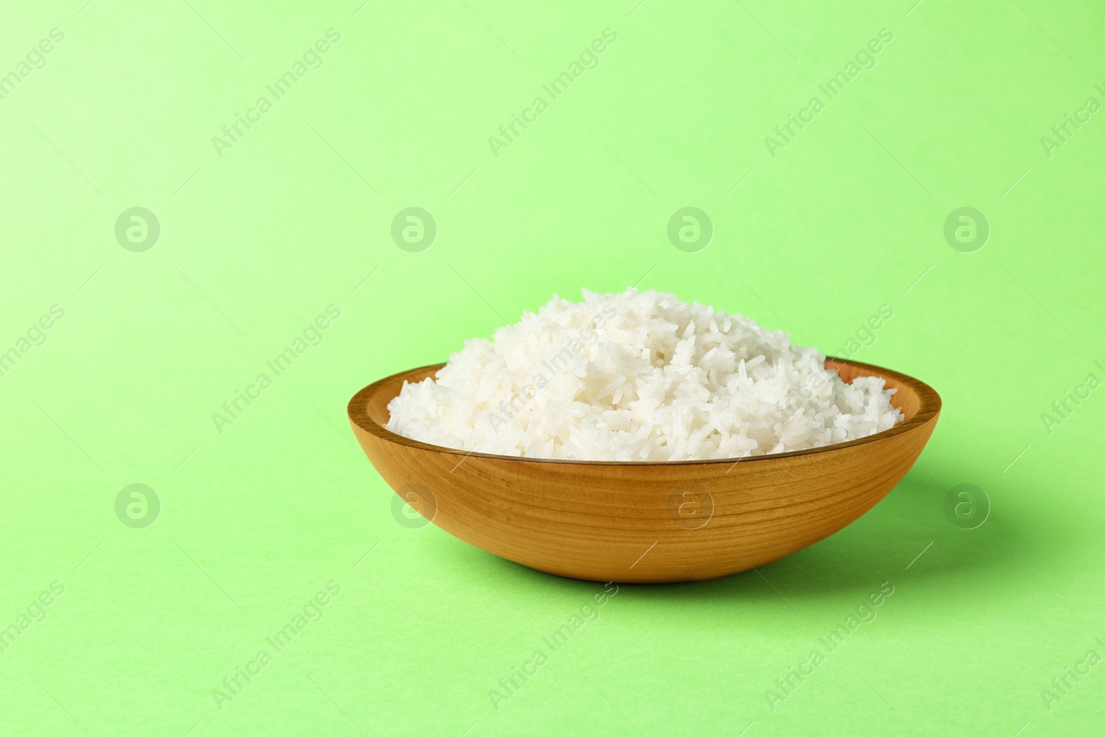 Photo of Bowl of boiled rice on color background. Space for text