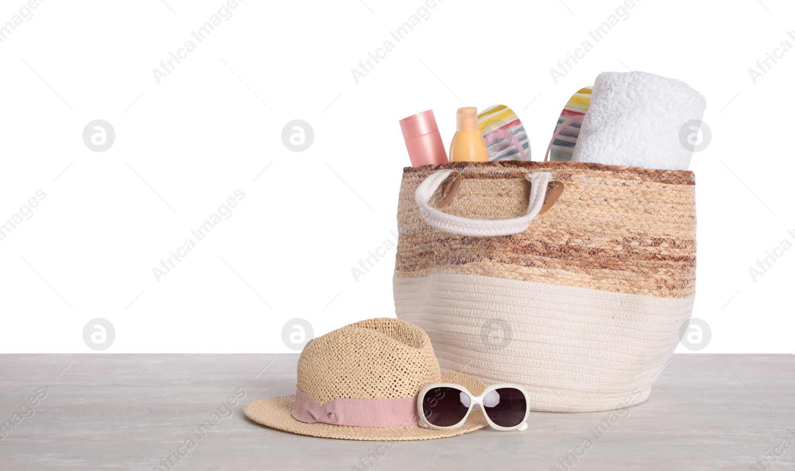 Photo of Bag with beach objects on table against white background. Space for text