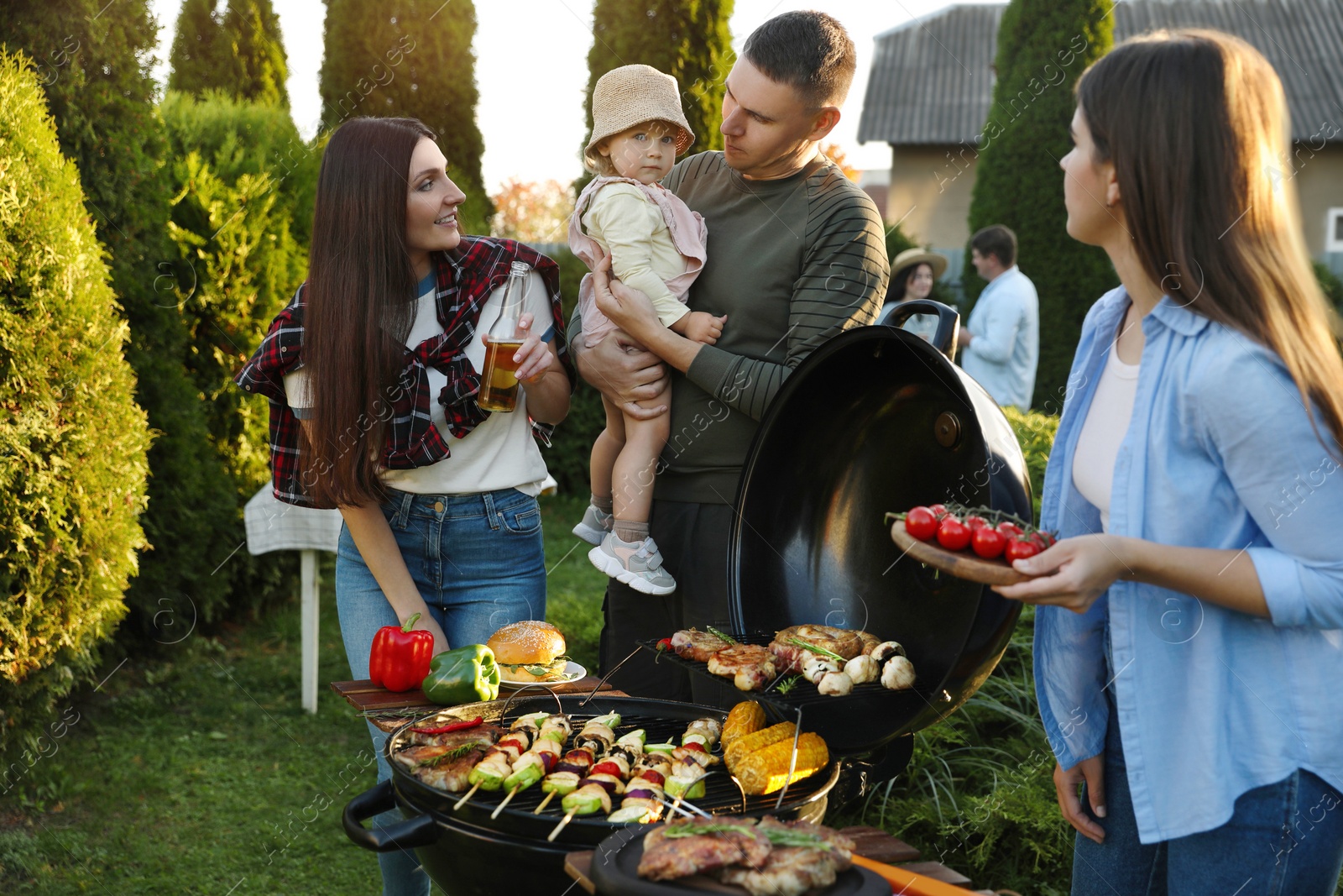 Photo of Family with friends having barbecue party outdoors