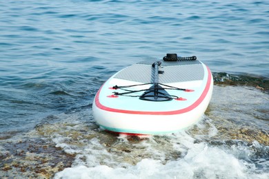 Photo of One SUP board with paddle near sea shore