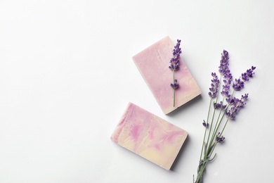 Handmade soap bars and lavender on white background, top view