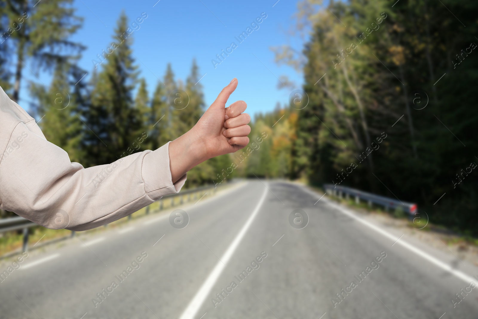 Image of Woman catching car on road, closeup. Hitchhiking trip