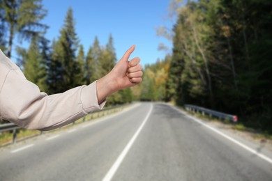 Woman catching car on road, closeup. Hitchhiking trip