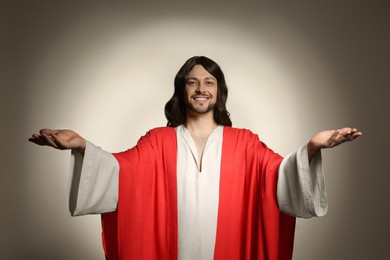 Jesus Christ reaching out his hands on beige background