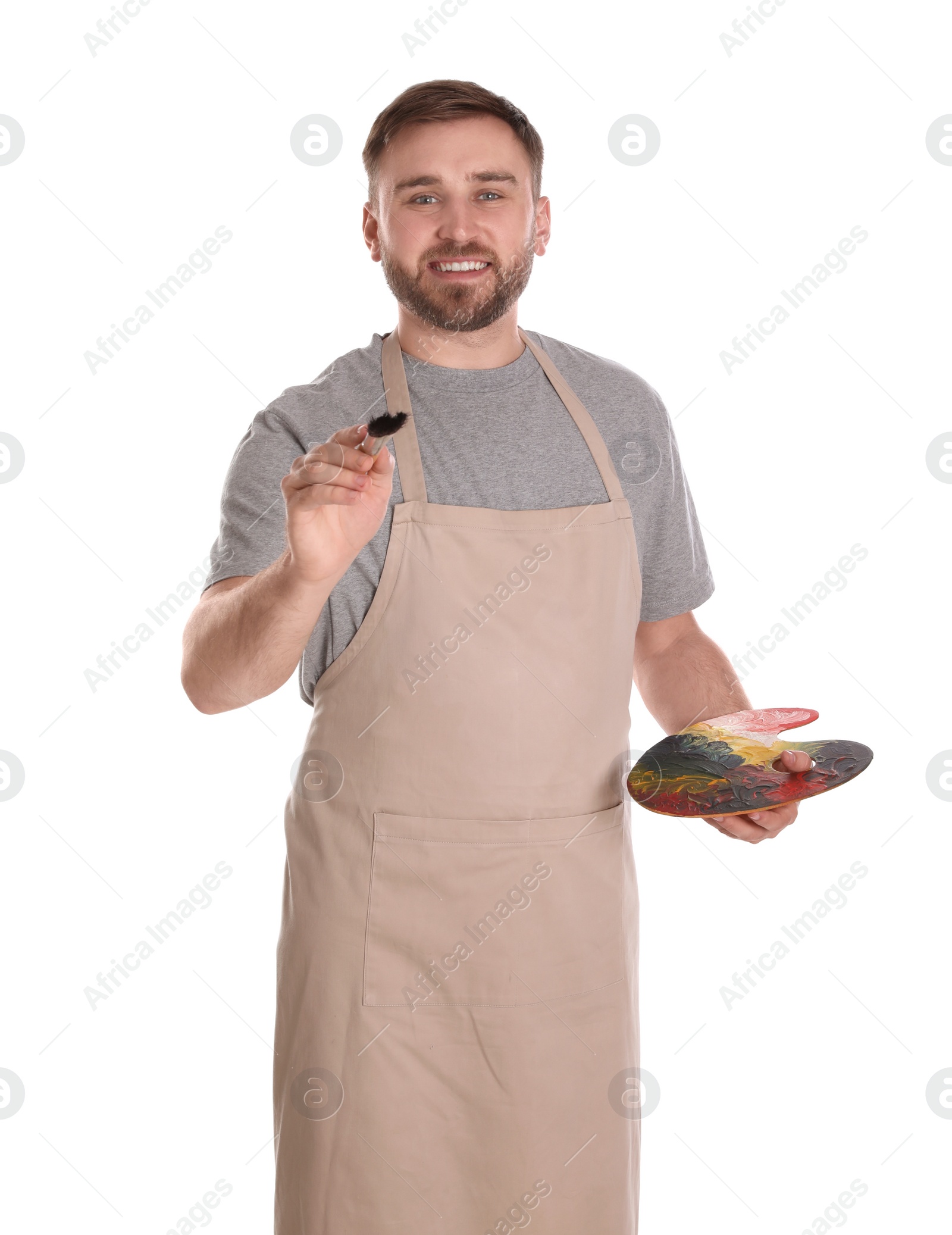 Photo of Man painting with brush on white background. Young artist