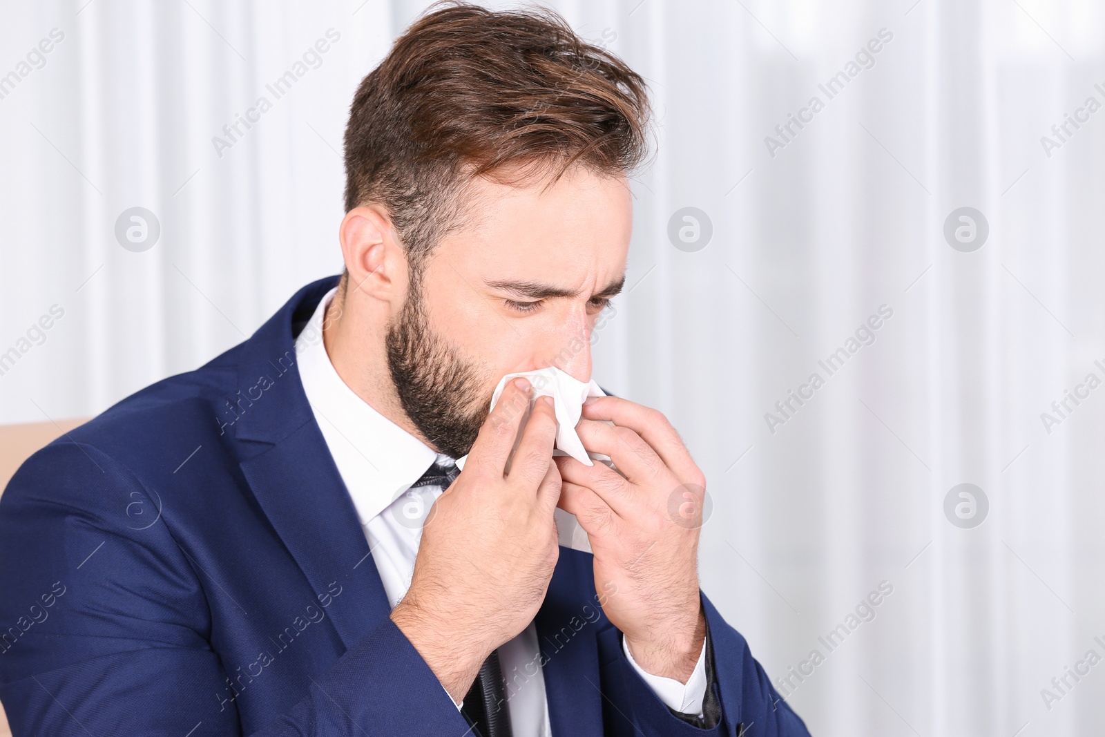 Photo of Ill businessman suffering from cough in office